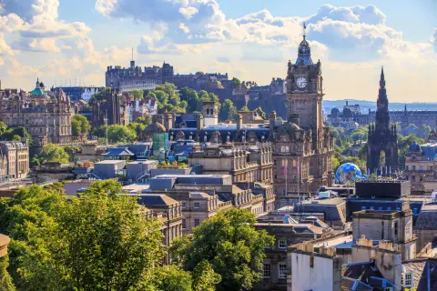 Edinburghs Skyline mit Schloss und Uhrenturm. Die beste Reisezeit für dieses Panorama ist im Sommer, wenn die Bäume grün sind.