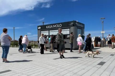Kasa Molo w Kołobrzegu. Ludzie stoją w kolejce, by dowiedzieć się, czy molo w Kołobrzegu jest płatne.