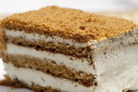 Tranche de gâteau à la crème et aux miettes de biscuit.