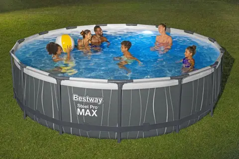 Rodzina pluska się w okrągłym basenie naziemnym Bestway Steel Pro MAX na trawniku.