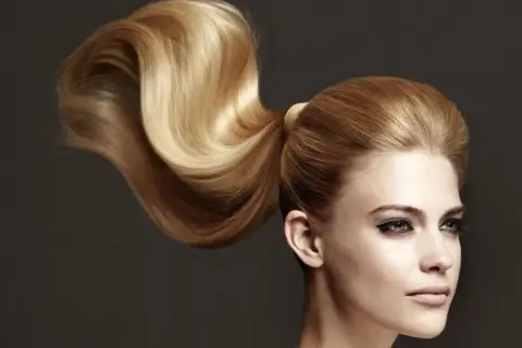 Ein voluminöser, goldblonder Pferdeschwanz, der elegant über die Schulter fällt. Perfekt für festliche pferdeschwanz frisuren.