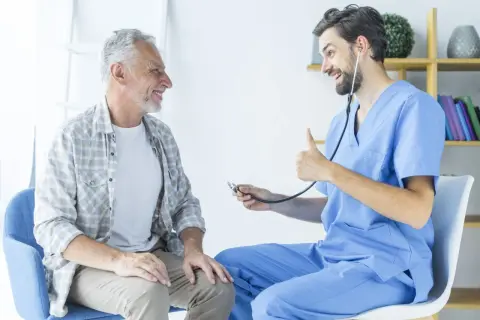 Un médecin rassure un patient âgé, lui expliquant l'espérance de vie après ablation de la prostate. Le docteur fait un pouce levé.