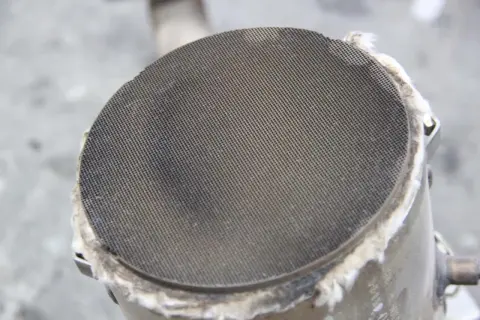 Widok z bliska na wkład filtra **FAP**, z widocznymi drobnymi otworami, które filtrują spaliny.