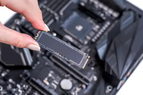 Eine Hand hält eine M.2 SSD, bereit für den Einbau in den entsprechenden ssd steckplatz mainboard.