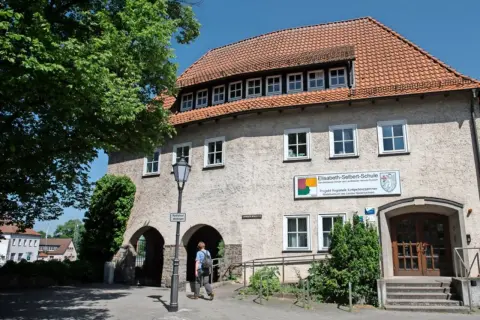 Elisabeth-Selbert-Schule, eine der besten Schulen Deutschlands, mit ihrem markanten roten Ziegeldach und einem Schild, das auf ihre Rolle als regionales Kompetenzzentrum hinweist.