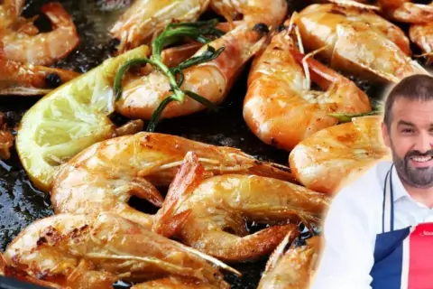 Gambones a la plancha dorados y jugosos, con limón y romero. Un chef sonriente los presenta.