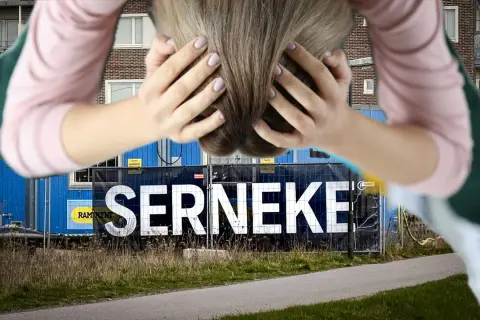 Person med händerna i håret framför en blå byggbarack med texten SERNEKE. En symbol för Serneke konkurs.