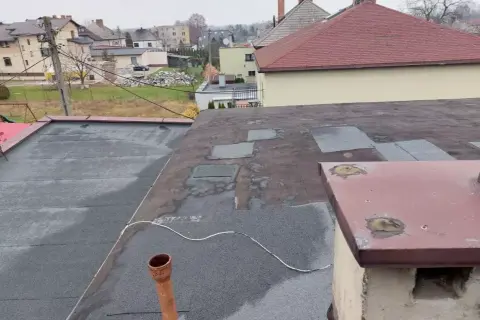 Dach płaski z papą, przygotowany do ocieplenia nakrokwiowego. Widoczny komin i rynna.