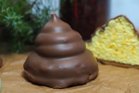 Chokladöverdragen maräng med en bit av en gul kaka med apelsinskal. Undrar om man kan frysa maräng?