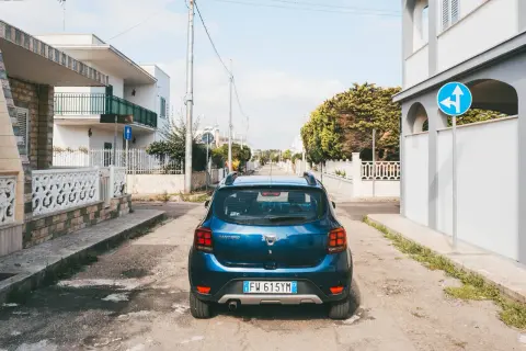 Blauer Mietwagen in Italien, bereit für Erkundungen. Hier sind einige mietwagen italien tipps für Ihre Reise.