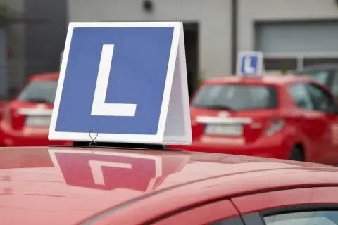 Nauka jazdy w Czechach: czerwone auto z literą "L" na dachu. To znak dla uczących się, jak zrobić prawo jazdy w Czechach.