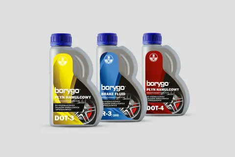 Trzy butelki płynu hamulcowego Borygo: DOT-3 (żółty), DOT-4 (czerwony) i jeden z oznaczeniem R-3/205 (niebieski).