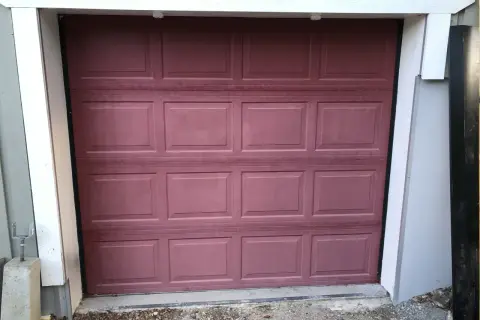 En mörkröd garageport i aluminium, redo att måla om för ett fräschare utseende.