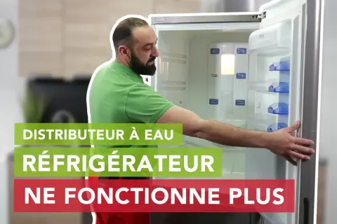 Un homme regarde un réfrigérateur Hisense ouvert, le distributeur à eau ne fonctionne plus.