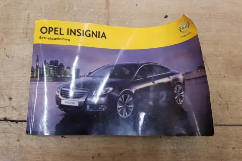Okładka instrukcji obsługi Opel Insignia z widokiem na ciemny samochód na tle nocnego miasta.