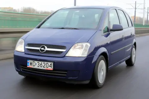 Niebieski Opel Meriva B jedzie po moście.