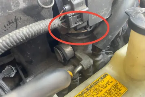 Silnik BMW z błędem DTC P0171. Czerwone koło zaznacza problem z przepływomierzem powietrza.