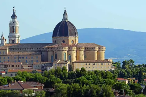 Basilica della Santa Casa a Loreto, vicino Ancona, con la sua imponente cupola e campanile, circondata da verde.