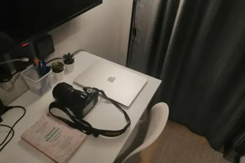 Na biurku leży aparat Nikon 3100, obok książka "Classical Mechanics" i laptop.