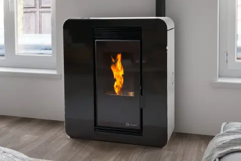 Estufa de pellets moderna con llama encendida. Instalación estufa pellets en un salón acogedor junto a la ventana.