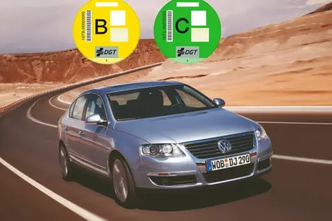Un coche plateado en una carretera desértica con pegatinas DGT. Averigua como saber si mi coche es Euro 6.
