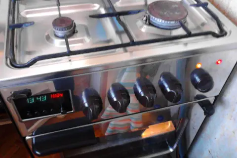 Instrukcja piekarnika Mastercook Wrozamet. Cyfrowy wyświetlacz pokazuje 13:43 i 100°C. Dwie lampki kontrolne świecą się na pomarańczowo i czerwono.