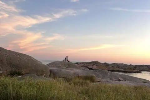 Två personer njuter av solnedgången vid Solvik camping Smögen. En idyllisk kväll vid havet.