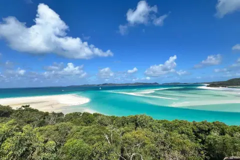 Widok na Whitehaven Beach z góry: turkusowa woda, biały piasek i zieleń.