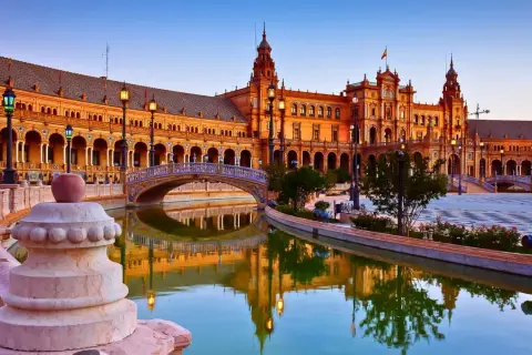 Plaza de España en Sevilla, uno de los lugares de España para visitar. Reflejos dorados en el canal y arquitectura impresionante.