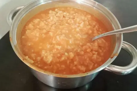 Gęsta zupa pomidorowa z ryżem w garnku, gotowa do podania. Idealna, by dowiedzieć się, jak zaprawić zupę pomidorową.