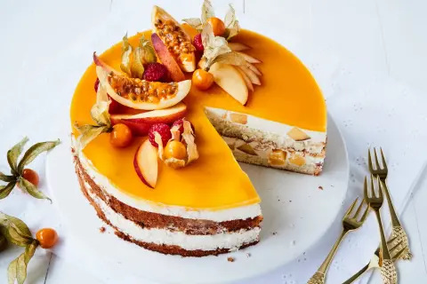 Eine köstliche Pfirsich Maracuja Torte, verziert mit frischen Früchten und Physalis. Ein Genuss für Augen und Gaumen!