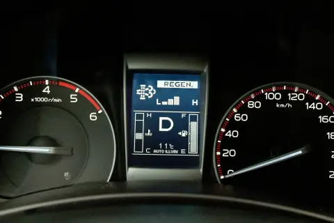 Wyświetlacz samochodu z ikoną "REGEN." i wskaźnikami obrotów, prędkości i paliwa.