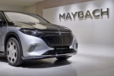 Elegancki Maybach błyszczy na tle logo marki. Poznaj jego wyjątkową **maybach cena** i poczuj luksus.