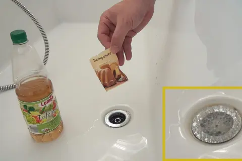 Hilfe bei verstopftem Waschbecken: Backpulver und Essig werden in den Abfluss gegeben, um die Verstopfung zu lösen.