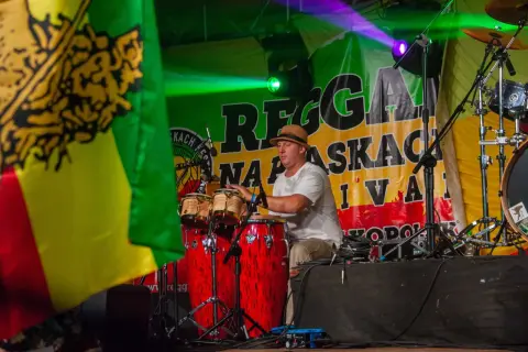 Perkusista polskiego zespołu reggae gra na congasach na scenie.