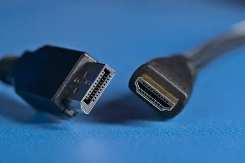 Złącza DisplayPort vs HDMI. Dwa kable, jeden z wtyczką DisplayPort, drugi z HDMI, gotowe do połączenia.