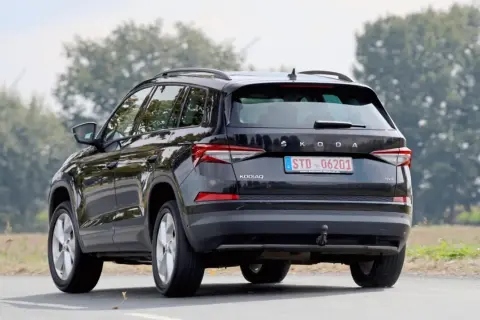 Svart Skoda Kodiaq kör på en landsväg. En snål bil som är perfekt för familjen och äventyr.