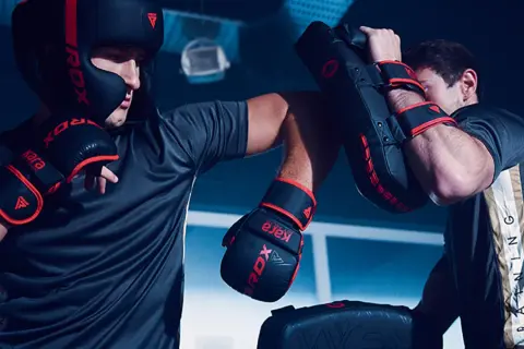 Two boxers train intensely, practicing punches and blocks. This focused training is key to learning how to win a boxing match.
