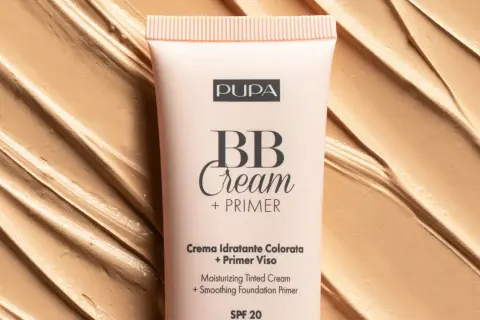 Tubo di BB Cream Pupa su sfondo di texture cremosa. Scopri come mettere la bb cream per un incarnato perfetto.