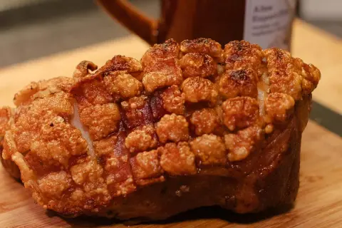 Knuspriger schweineschulterbraten mit perfekt aufgeplatzter Schwarte, bereit zum Genuss.