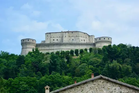 Rocche imponenti e torri rotonde dominano la collina, circondate da un verde lussureggiante. Un gioiello tra i borghi dell'Emilia Romagna.