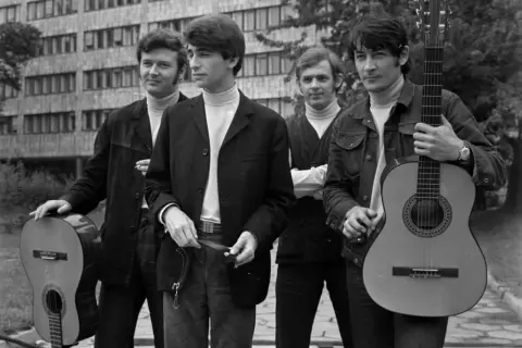 Czterech młodych mężczyzn z gitarami, jakby gotowi do zagrania "czerwone gitary historia jednej znajomości tekst".