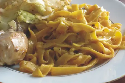 Pyszne tagliatelle z kurczakiem i warzywami na talerzu.