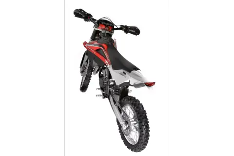 Husqvarna WR 125 gotowy do akcji. Czerwono-biały motocykl crossowy z grubymi oponami i wyścigowym designem.