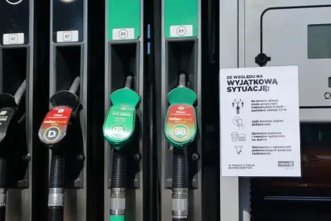 Dwa dystrybutory paliwa, jeden z oznaczeniem 95, drugi z 98. Obok tabliczka z zasadami bezpieczeństwa.