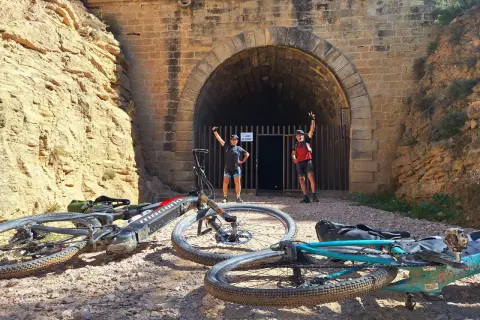 Ciclistas posan ante un túnel, una parada interesante que ver cerca de Alcañiz.