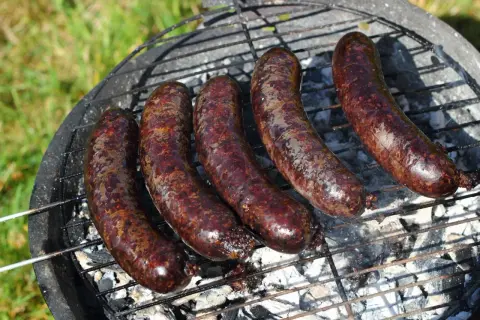 Pięć soczystych kaszanek z grilla, rumieniących się na ruszcie nad żarem. Idealne na letnie popołudnie.