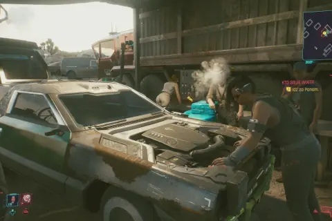 Kto sieje wiatr w cyberpunkowym świecie, naprawia auto. W tle widać ciężarówkę i innych ludzi.