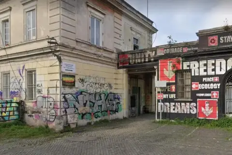 Ingresso del centro Ararat, con graffiti colorati e messaggi di libertà, pace ed ecologia.