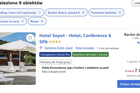 Białe leżaki i parasole na plaży przed budynkiem hotelu.